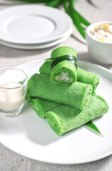 Dadar Gulung or Dadar Unti is Indonesian traditional finger food (jajan pasar), is grated coconut sweetened with palm sugar wrapped in pandan crepes.