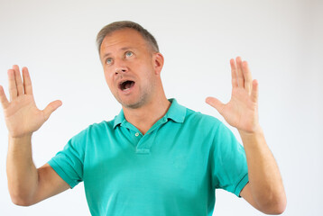 Excited young man in casual t-shirt over white background.