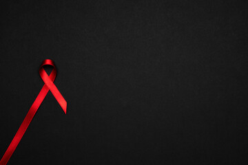 Hiv support. Red ribbon symbol in hiv world day on black background. Awareness aids and cancer. Aging Health month concept.