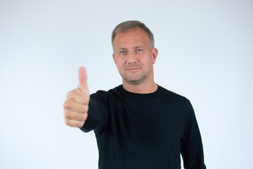 Happy man wearing casual black sweater with thumb up sign on white background