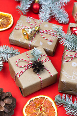 Merry christmas gift boxes still life on red background. Present wrapped paper diy, eco christmas decor Zero waste