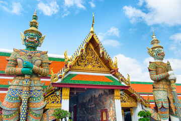 Fototapeta premium Gold decorated gates with two mythical demon guardians. Grand Palace, Bangkok, Thailand