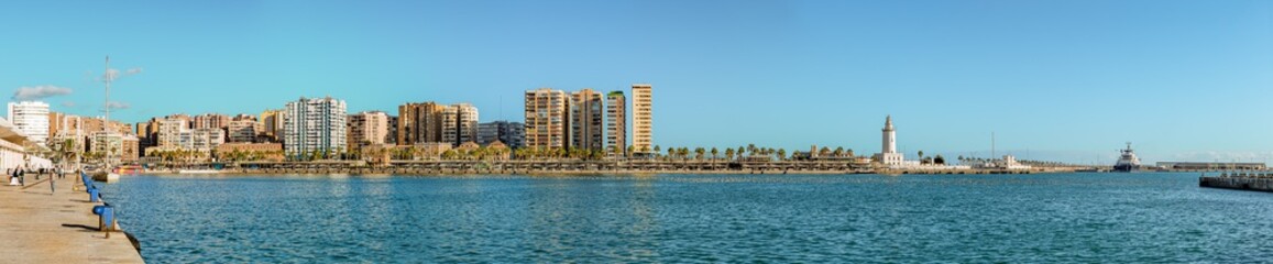 Panorama of "Palmeral de las sorpresas". an architectural structure in the the promenade of the port of Malaga. "Muelle Uno" shopping mall,Malagueta buildings, main park and La Farola lighthouse 