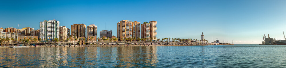 Panorama of "Palmeral de las sorpresas". an architectural structure in the the promenade of the port of Malaga. "Muelle Uno" shopping mall,Malagueta buildings, main park and La Farola lighthouse