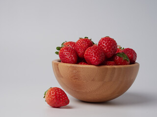 Fresh ripe delicious strawberries in a bowl on a white background