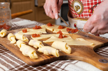 Woman preparing homemade rolls with jam  at home