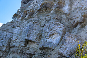 sandy-gypsum cut of the earth in quarry for the extraction of gypsum. Mountain textures of different soil layers with deposits of sand, clay, gypsum, quartz and gypsum ore, after erosion.