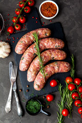 Bavarian or Munich hot sausages with seasonings and sauces on a stone board. - 396757243