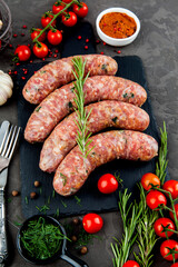 Grilled sausages with rosemary herbs and tomatoes on a black background. Top view - 396757275