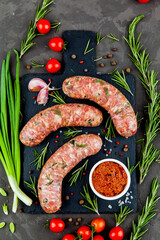 Bavarian or Munich hot sausages with seasonings and sauces on a stone board. - 396757429