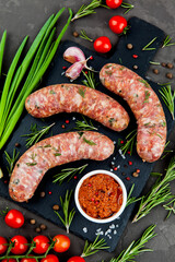 Bavarian or Munich hot sausages with seasonings and sauces on a stone board. - 396757476