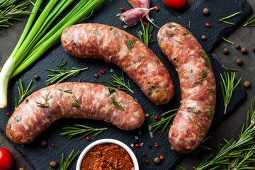 Bavarian or Munich hot sausages with seasonings and sauces on a stone board. - 396757660