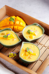 Mango sago. Sweet sago cream with mango, coconut milk and mango juice garnish with edible flower.