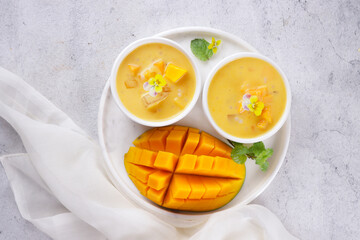 Mango sago. Sweet sago cream with mango, coconut milk and mango juice garnish with edible flower.