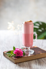 Pink Latte Tea. Pink hibiscus latte. Fashionable romantic drink. Dry flowers of roses. Pink background