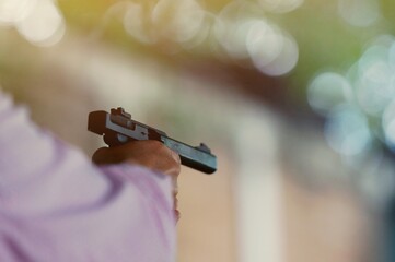 law enforcement aim pistol by two hand in academy shooting range in flare and vintage color, focus at rear gun sight