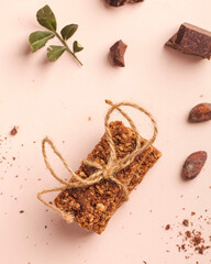 Flatlay Granola bar with chocolate on a pink background. Healthy snack, vegan snack. Copy space.