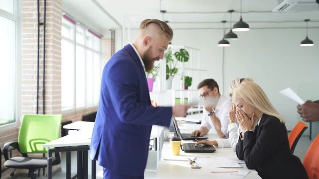 Male director in formal wear scolds female employee, going to fire her from work, makes comments among others, woman is scrying, she is humiliated.