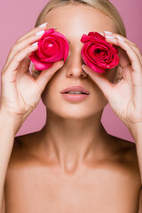 Naklejka premium beautiful blonde woman with rose flowers on eyes isolated on pink