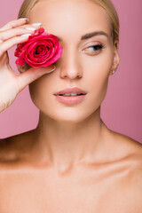Fototapeta na wymiar beautiful blonde woman with rose flower on eye isolated on pink