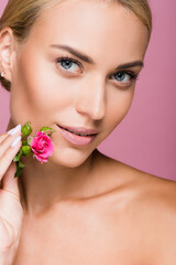 Fototapeta na wymiar beautiful blonde woman with perfect skin and rose flower isolated on pink