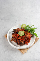 Sambal or penyet Ikan panggang or ikan manyung asap is ariidae fish preserved by fumigation sauce. Smoked ariidae fish sell in the traditional market in Indonesia.