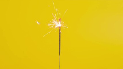 Lightening Christmas sparkler on the yellow background.