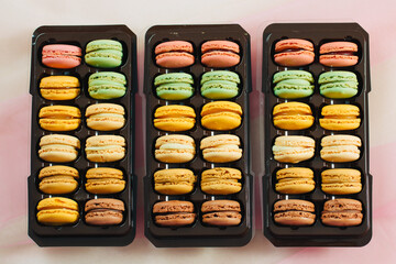 3 brown boxes with macarons in different colors