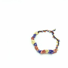 Women's bijouterie. Multi-colored necklace. Beads of pink, purple, white flowers are in the shape of petals and look like a flower garland. Metal clasp. Isolated on white background.