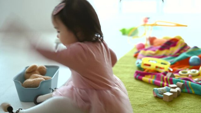 おもちゃのブロックを投げて遊ぶ赤ちゃん