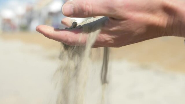 Main qui laisse tomber du sable sur la plage, Dunkerque, Hauts-de-France 