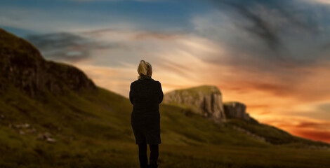 Silhouette of a woman walking in nature green mountain valley.