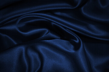 Dark blue elegant background. Crumpled satin texture background. The surface of a dark blue shiny...
