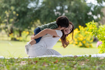 Obraz premium Asian family having fun mother and her son playing in the park together