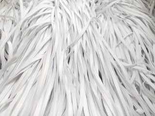 Lots of white elastic bands for clothes, face masks, underwear. Background on the theme of light industry
