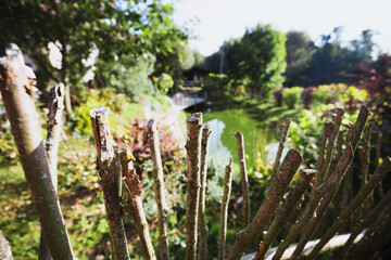 Homemade branch fence along the pond - backyard and landscaping