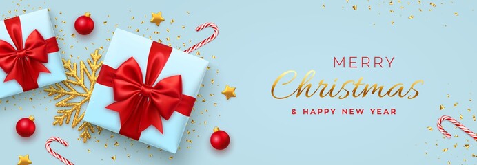 Fototapeta na wymiar Christmas banner. Realistic blue gift boxes with red bow, gold stars, shiny golden snowflake, balls and candy canes. Xmas background, horizontal poster, greeting card, header website. Vector.