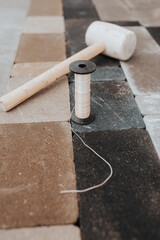 Marking cord and rubber mallet on paving slabs - bricklayer and tiler tools