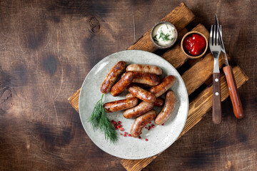 Bavarian sausages. Pork sausages in a plate on a brown wooden table. Delicious Nuremberg sausages	