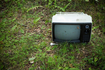 Retro television in the green grass. 