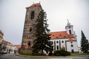 Gothic medieval stone bell tower and baroque saint Gothard church in old historic center of Cesky Brod, Christmas tree and Christmas decorations, Central Bohemia, Czech Republic