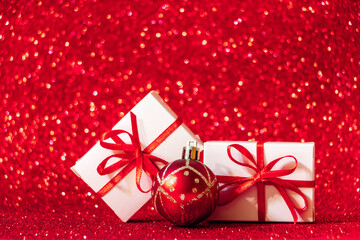 Gift boxes on red glittering background. Christmas concept, place for text.