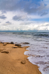 Empty beach and stormy sea in cloudy weather