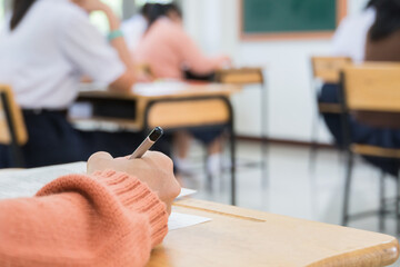 Hand student taking exam or test in exercise taking fill in exam carbon paper computer sheet with pencil at school in test room. education examination concept © smolaw11