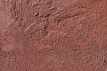 Rustic plaster on distressed wall. Concrete photo texture. Orange red texture. Grungy grit painted wall in sunlight. Rough concrete closeup for retro design. Abstract weathered plaster background