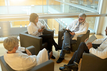 Obraz premium Medical people sitting in meeting room, checking planning together