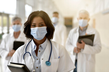 Woman doctor standing in hospital, wearing face mask