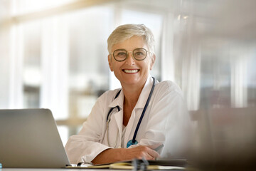 Mature female practitioner working on laptop computer