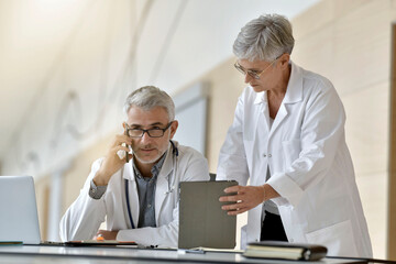 Fototapeta premium Doctor and nurse sharing information about medical report