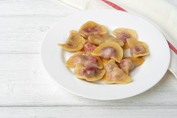 Russian dumplings on white plate on white wooden table